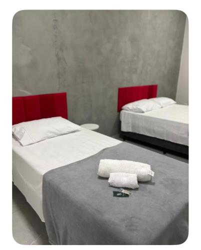 two beds with towels on a table in a room at Quartos Sinop in Sinop