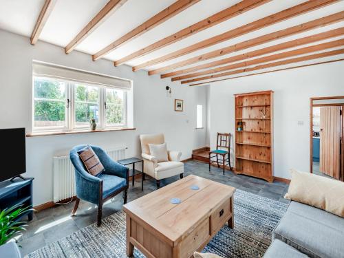 a living room with a couch and a table at The Pink Cottage in Bottisham