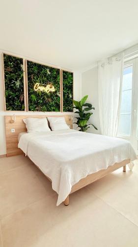 a white bedroom with a large bed in front of windows at Casa Bali centre ville in Brie-Comte-Robert