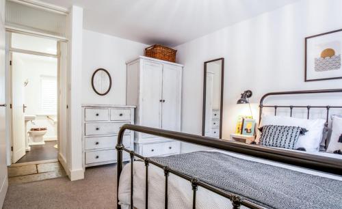 a bedroom with a bed and a dresser at Blackshore House in Wenhaston