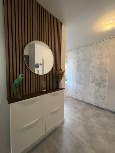 a hallway with a mirror and a parrot on a wall at Glory's Apartment in Dußlingen