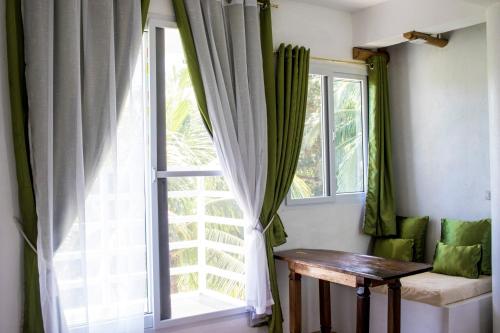 a window with green curtains and a wooden table at Lanterna Hotel Boracay in Boracay