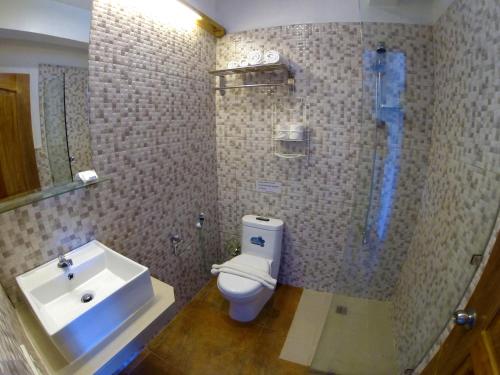 a bathroom with a shower and a toilet and a sink at Lanterna Hotel Boracay in Boracay