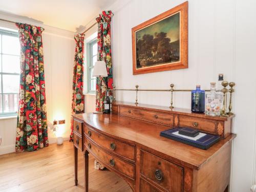 a room with a wooden dresser and a painting on the wall at Schiehallion House in Pitlochry