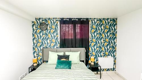 a bedroom with a bed with blue and yellow wallpaper at La Parenthèse Urbaine - T2 Cosy et fonctionnel - Metro 5 Bobigny in Bobigny