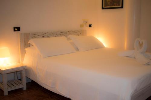 a bed with white sheets and pillows in a bedroom at Lanterna Hotel Boracay in Boracay