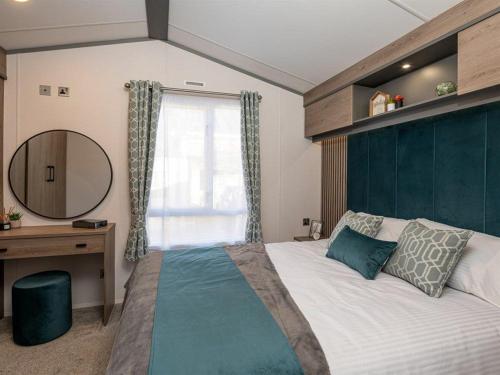 a bedroom with a large bed and a mirror at Jackson Lodge - Primrose in Malton