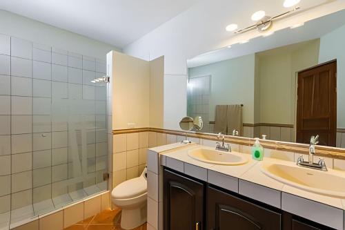 a bathroom with two sinks and a toilet and a mirror at Coco Sunset Hills 52 in Coco