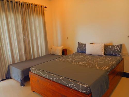 a bedroom with two beds and a window at Hotel krish in Kalkudah
