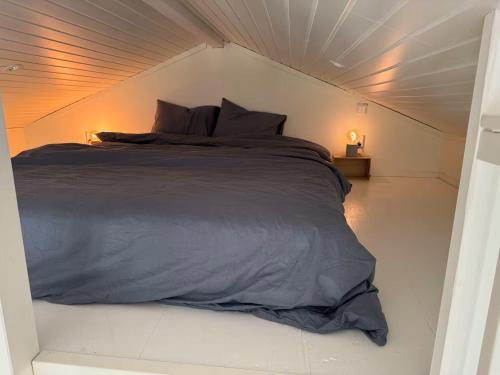 a bed in a white room with two lamps at Cozy guesthouse in Vallda in Vallda