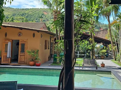 a house with a swimming pool in front of a house at Hostel Jai Juquehy in Juquei