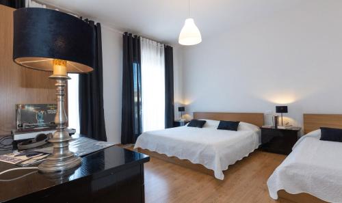 a bedroom with a bed and a desk with a lamp at Lizard Residence in Lido di Jesolo