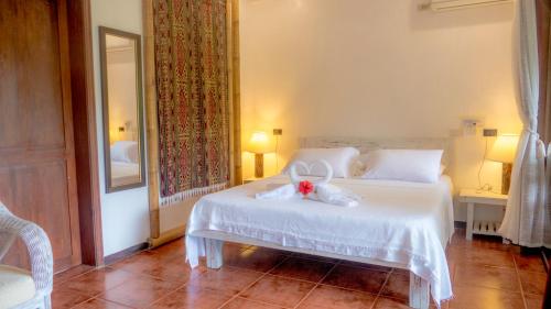 a bedroom with a white bed with a bow on it at Lanterna Hotel Boracay in Boracay