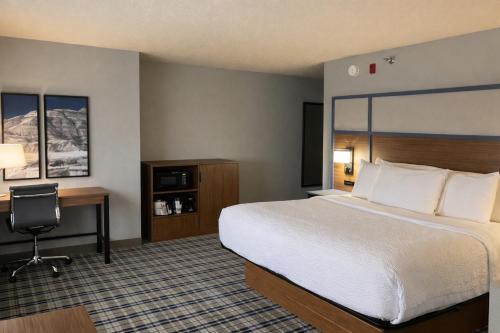 a hotel room with a bed and a desk at AmericInn by Wyndham Dickinson in Dickinson