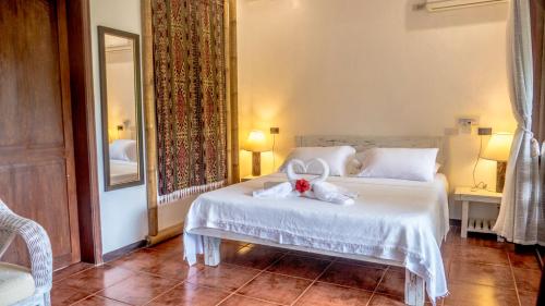 a bedroom with a white bed with a stuffed animal on it at Lanterna Hotel Boracay in Boracay