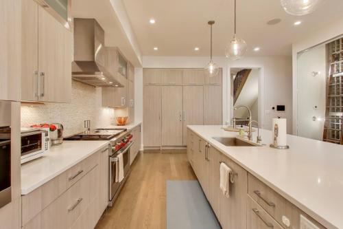 a large kitchen with white counters and a sink at Hello Again, Chicago! in Chicago