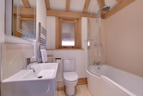 a bathroom with a sink and a tub and a toilet at 2 Bed in Tenterden oc-tn606 in Stone