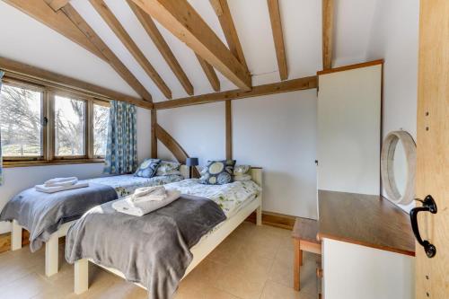 two beds in a room with wooden ceilings at 2 Bed in Tenterden oc-tn606 in Stone