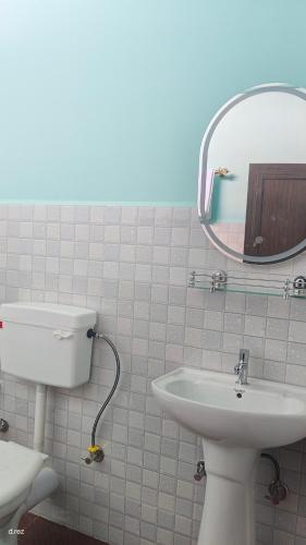 a bathroom with a sink and a mirror and a toilet at Eyana Residency in Lāitlyngkot