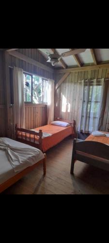 a bedroom with three beds in a room at Portal de maria in Imbituba