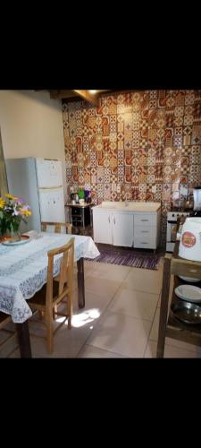 a kitchen with a table and a table and a refrigerator at Portal de maria in Imbituba