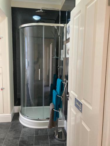 a bathroom with a glass shower with blue towels at Gull Rock, close to Tunnels Beach & Harbour with Parking in Ilfracombe