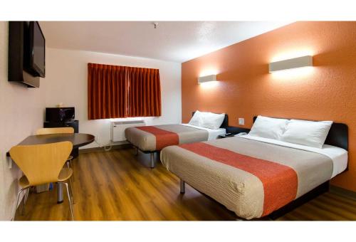 a hotel room with two beds and a desk at Motel 6 Kerrobert, SK in Kerrobert