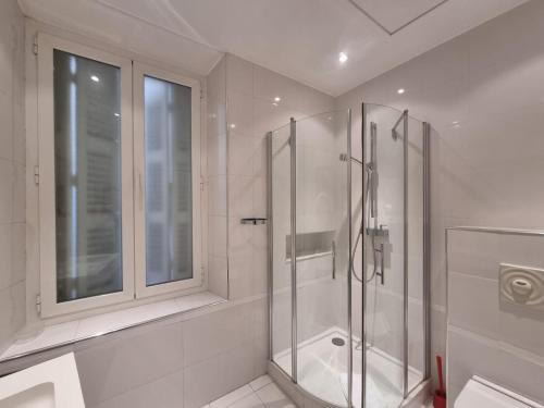 un baño blanco con ducha y ventana en Appartement Commandant André, en Cannes