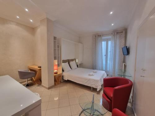 un dormitorio con una cama y una silla roja en Appartement Commandant André, en Cannes