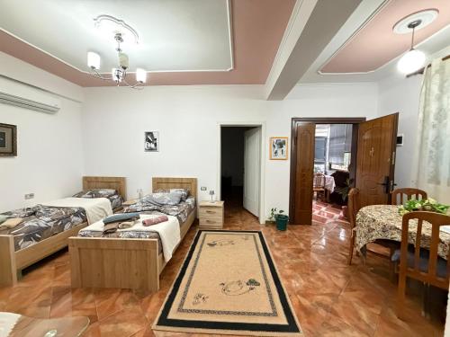 a living room with two beds and a dining room at Guest House Flowers in Berat