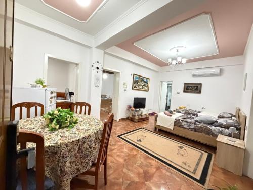 a living room with a table and a bed at Guest House Flowers in Berat