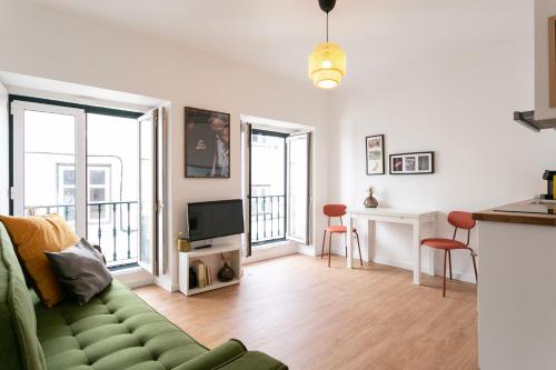 a living room with a green couch and a television at Severa Apartments in Lisbon
