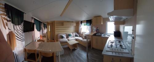 a small kitchen and living room in a tiny house at location mobile home proche de la mer in Hermanville-sur-Mer