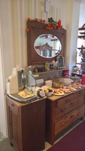 a buffet with food on a table with a mirror at Stoevchen Café Hotel in Papenburg