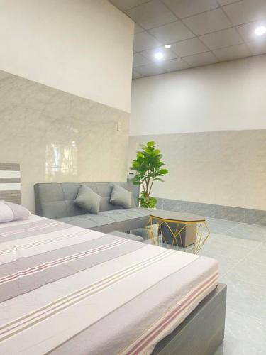 a hotel room with a bed and a couch at Homestay Vườn Dừa in Ấp Nhứt (1)
