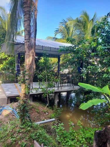 a bridge over a pond with a table and a palm tree at Homestay Vườn Dừa in Ấp Nhứt (1)