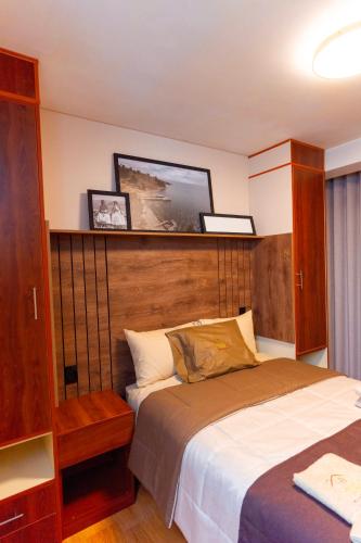a bedroom with a bed with a wooden headboard at Samaran Wuasi in Puno