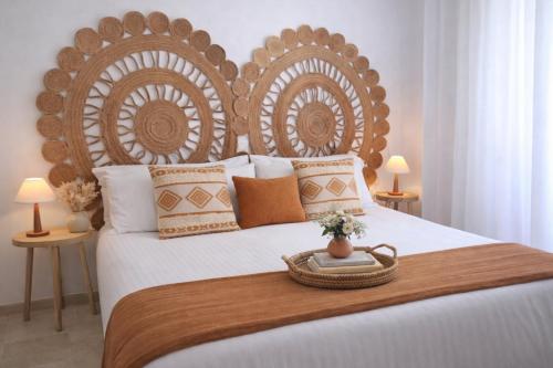 a bed with a wooden headboard with a basket on it at Noctua Manilva Sea View 023 in Manilva
