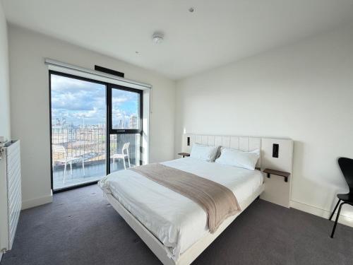 a bedroom with a large bed and a large window at Silver Apartments ExCel in London