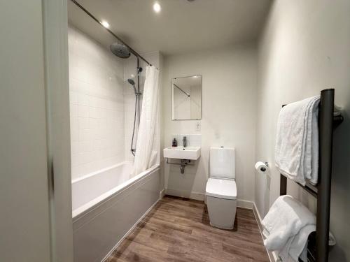 a white bathroom with a sink and a toilet at Silver Apartments ExCel in London