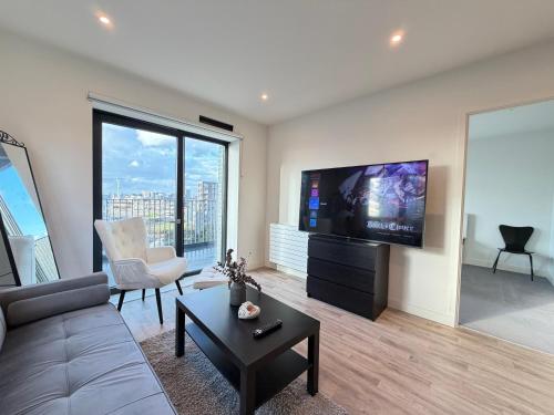 a living room with a couch and a flat screen tv at Silver Apartments ExCel in London