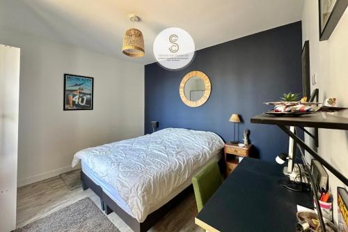 a small bedroom with a bed and a table at L'Orangeraie Arles in Arles