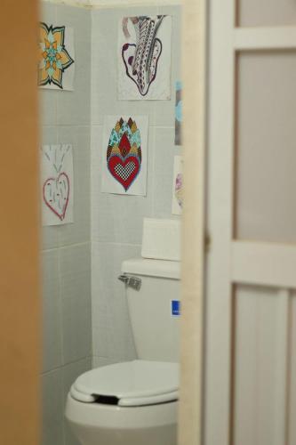 a bathroom with a toilet and some pictures on the wall at El jardin in Brisas de Zicatela