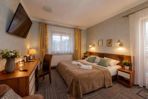 a hotel room with a bed and a desk at WILLA PETRUS - CENTRUM BALKONY WINDA ŚNIADANIA RELAKS I WYGODa in Karpacz