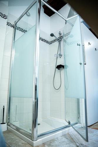 a shower with a glass enclosure in a bathroom at La Ferme de la Gronde in Magny-en-Bessin