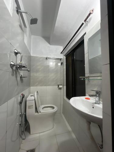 a white bathroom with a toilet and a sink at Kathmandu Valley View Homestay in Kathmandu