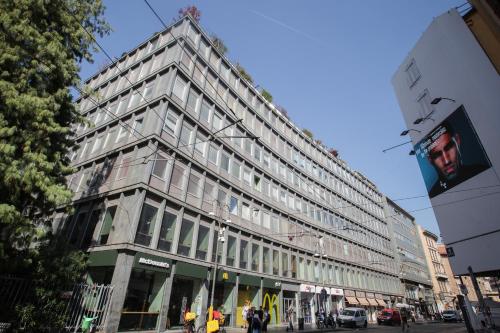 a large building on a city street with people walking in front at TheROOMS by TheFLOOR Collection in Milan