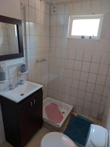 a bathroom with a sink and a tub and a toilet at Ushuaia centro Complejo de Cabañas in Ushuaia