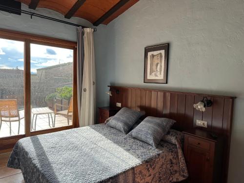 a bedroom with a bed with a view of a balcony at Can Genis Turismo Rural in Peralada