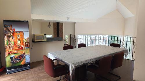 a dining room with a table and chairs and a television at Araucária Lodge - 800 metros do Capivari in Campos do Jordão